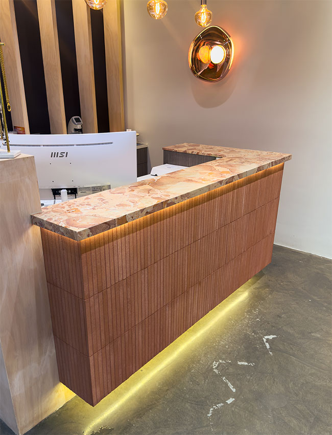 Polished marble counter with a protected top, above a ribbed terracotta base.